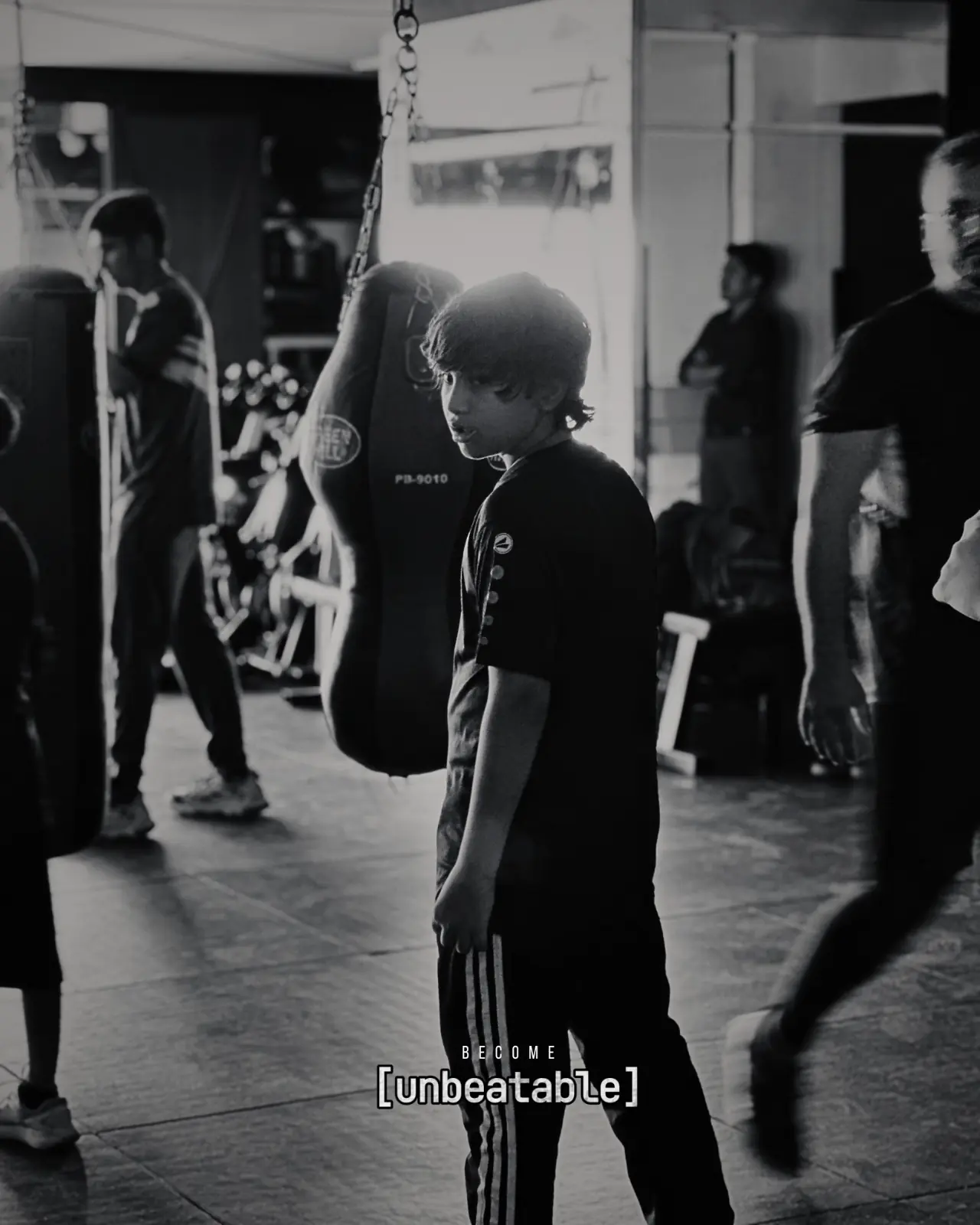 A young participant catches his breath beside a heavy bag